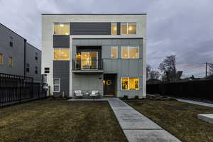 Rear view of property with a lawn and a patio area