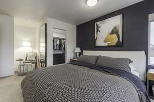 Carpeted bedroom featuring a closet, a walk in closet, and a textured ceiling