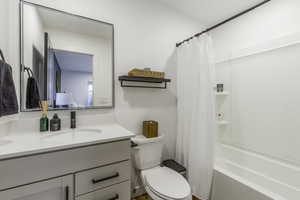 Full bathroom featuring toilet, vanity, and shower / tub combo