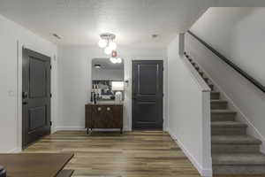 Foyer entrance featuring a textured ceiling and hardwood / wood-style flooring