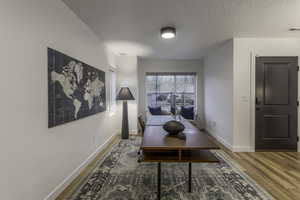 Office area featuring wood-type flooring and a textured ceiling