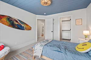 Carpeted bedroom with wood ceiling