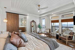 Primary Bedroom featuring wood-type flooring, ensuite bath, a tray ceiling, and wood ceiling