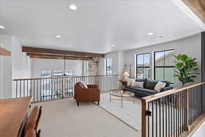 Carpeted living room with a textured ceiling