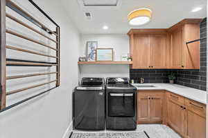 Laundry area featuring sink, cabinets, and washing machine and dryer