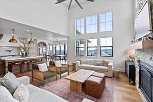 Living room with ceiling fan and light hardwood / wood-style flooring