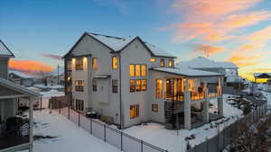 Snow covered rear of property featuring a balcony