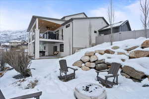 Snow covered property with ceiling fan and a balcony