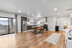 Dining space with a textured ceiling, sink, and light hardwood / wood-style floors