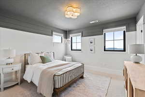 Bedroom featuring carpet floors and a textured ceiling