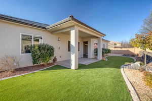 Back of house with a patio and a yard