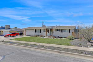 Single story home featuring a garage, fence, a front lawn, brick siding, and driveway