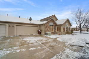 Ranch-style home with a garage, a sunroom, and central air condition unit