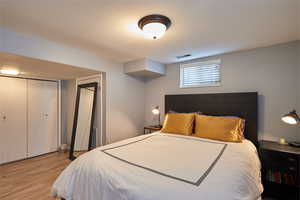 Bedroom with light hardwood / wood-style floors and a closet