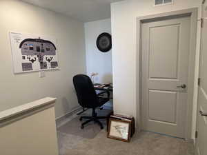 Home office featuring light colored carpet