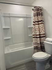 Bathroom featuring shower / bath combination with curtain and toilet