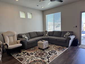 Living room with ceiling fan, wood-type flooring, and a textured ceiling