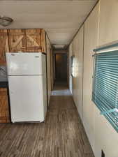 Interior space with wood finished floors and freestanding refrigerator