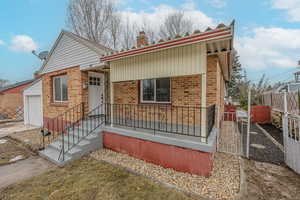 View of front of property featuring a garage, an outdoor structure, and a porch