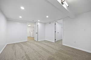 Basement featuring light carpet and separate washer and dryer