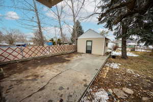 Snow covered patio with an outbuilding