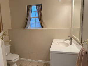 Bathroom featuring tile patterned floors, toilet, and vanity