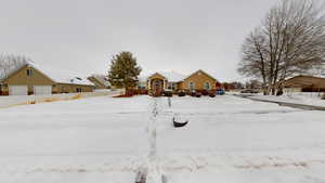 Yard layered in snow featuring a garage