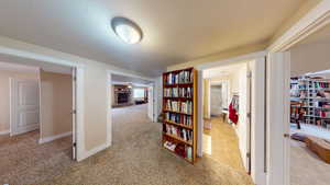 Corridor with a textured ceiling and light colored carpet