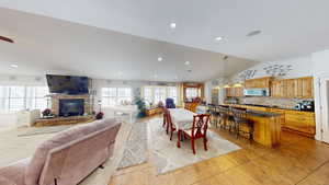 Dining space featuring vaulted ceiling and a stone fireplace