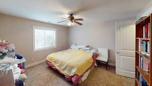 Carpeted bedroom featuring ceiling fan