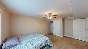 Carpeted bedroom with a closet and ceiling fan