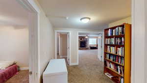 Hall featuring light colored carpet