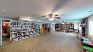 Sitting room with carpet, a textured ceiling, and a fireplace