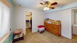 Bedroom featuring ceiling fan, a closet, light colored carpet, and a spacious closet