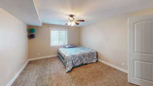 Bedroom with carpet, a textured ceiling, and ceiling fan