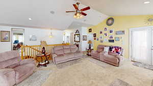 Living room with light carpet, vaulted ceiling, and ceiling fan