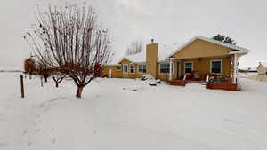 Snow covered property featuring a porch