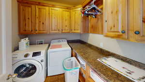 Laundry room featuring cabinets, tile patterned flooring, and washing machine and clothes dryer