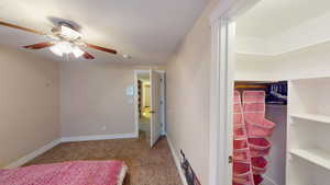 Unfurnished bedroom featuring carpet flooring and ceiling fan