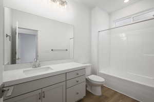 Bathroom with shower / tub combination, toilet, vanity, and wood finished floors