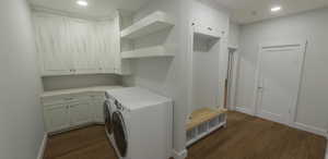 Washroom with cabinets, separate washer and dryer, and dark hardwood / wood-style floors