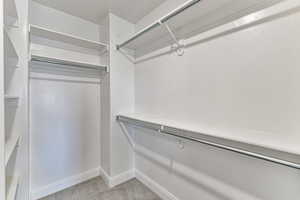 Walk in closet with light colored carpet