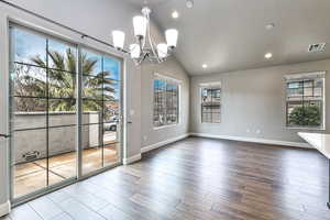 Unfurnished dining area featuring lofted ceiling, hardwood / wood-style floors, and plenty of natural light