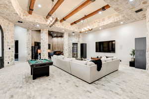 Living room with billiards, a towering ceiling, and beam ceiling