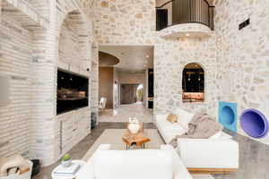 Living room featuring hardwood / wood-style flooring, sink, and a towering ceiling