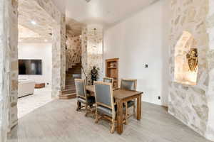 Dining room with light hardwood / wood-style flooring and a high ceiling