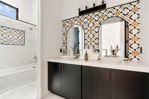 Bathroom featuring tiled shower / bath combo and vanity