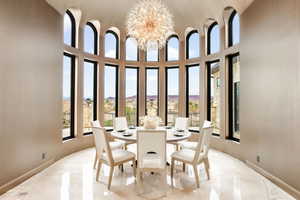 Dining space with a mountain view, a chandelier, and a towering ceiling