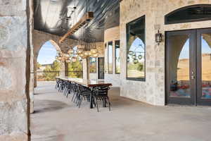 View of patio / terrace featuring french doors, fence, and a ceiling fan