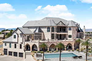 Rear view of house with a patio, a garage, and a balcony